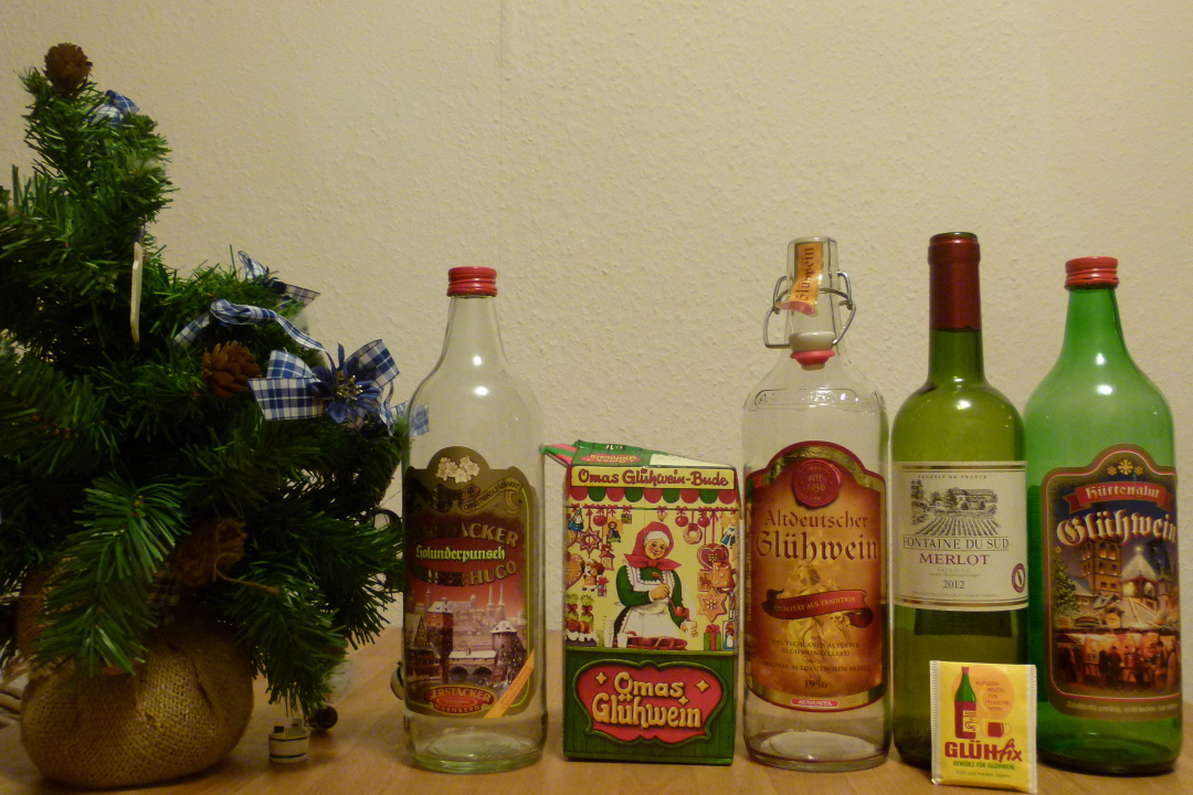 Drei Flaschen Glühwein, ein Tetrapak und eine Flasche Merlot mit „Glühfix“
